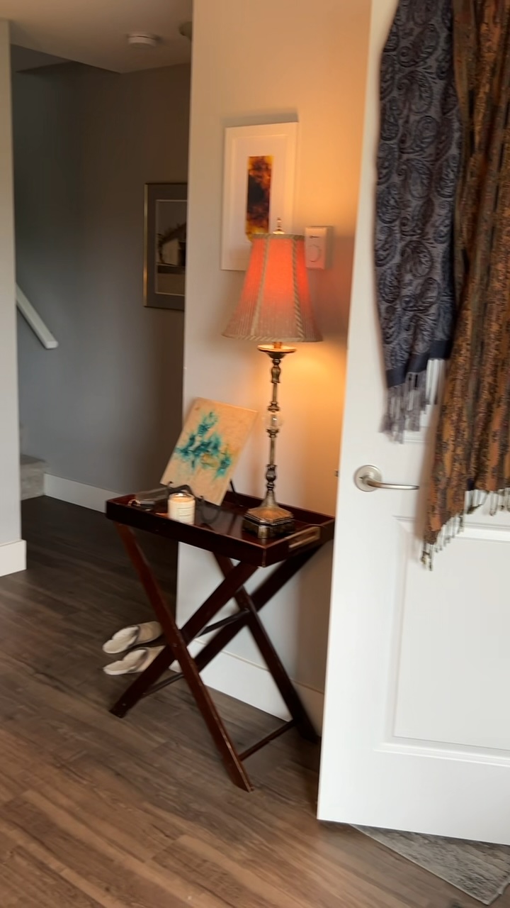 After: A tray table and lamp by the door, with scarves hung up